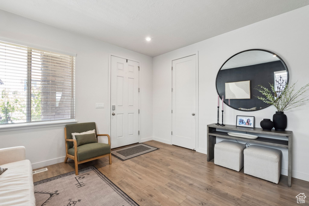 Entrance foyer with baseboards, wood finished floors, and recessed lighting