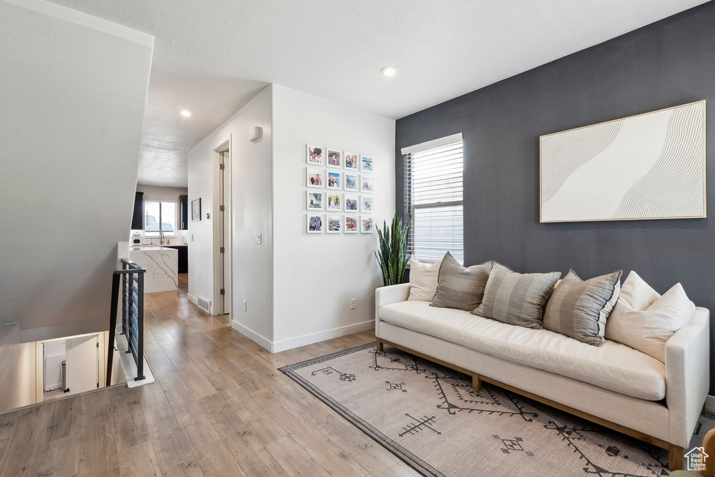 Living room with wood finished floors, baseboards, and recessed lighting