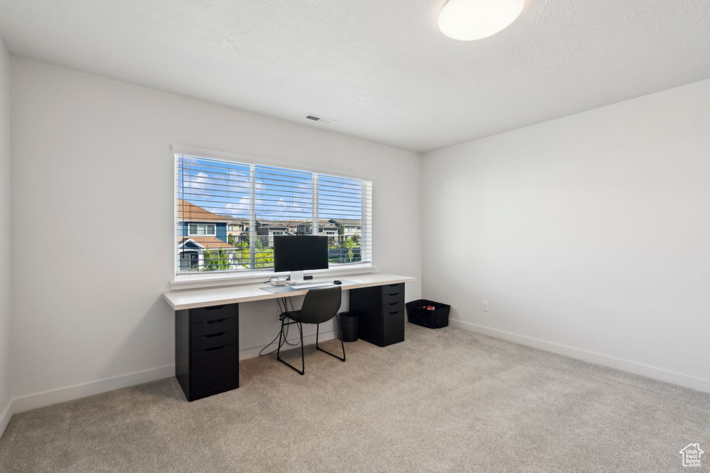 Office featuring light colored carpet and baseboards