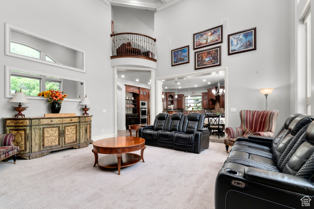 Carpeted living room with a towering ceiling, crown molding, healthy amount of natural light, and baseboards