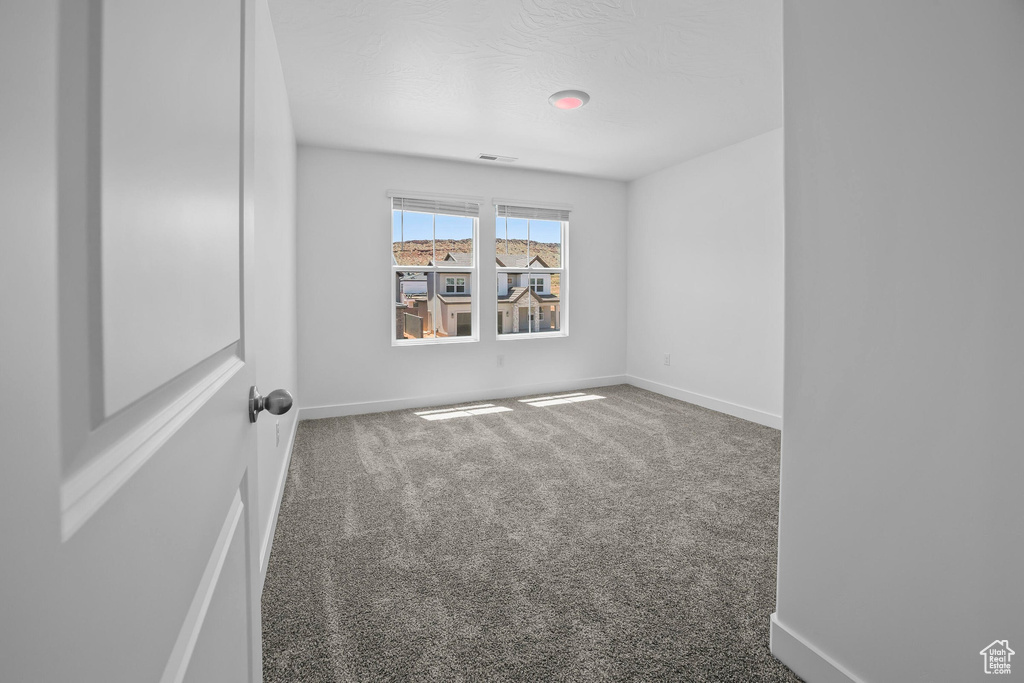 Spare room featuring carpet and baseboards
