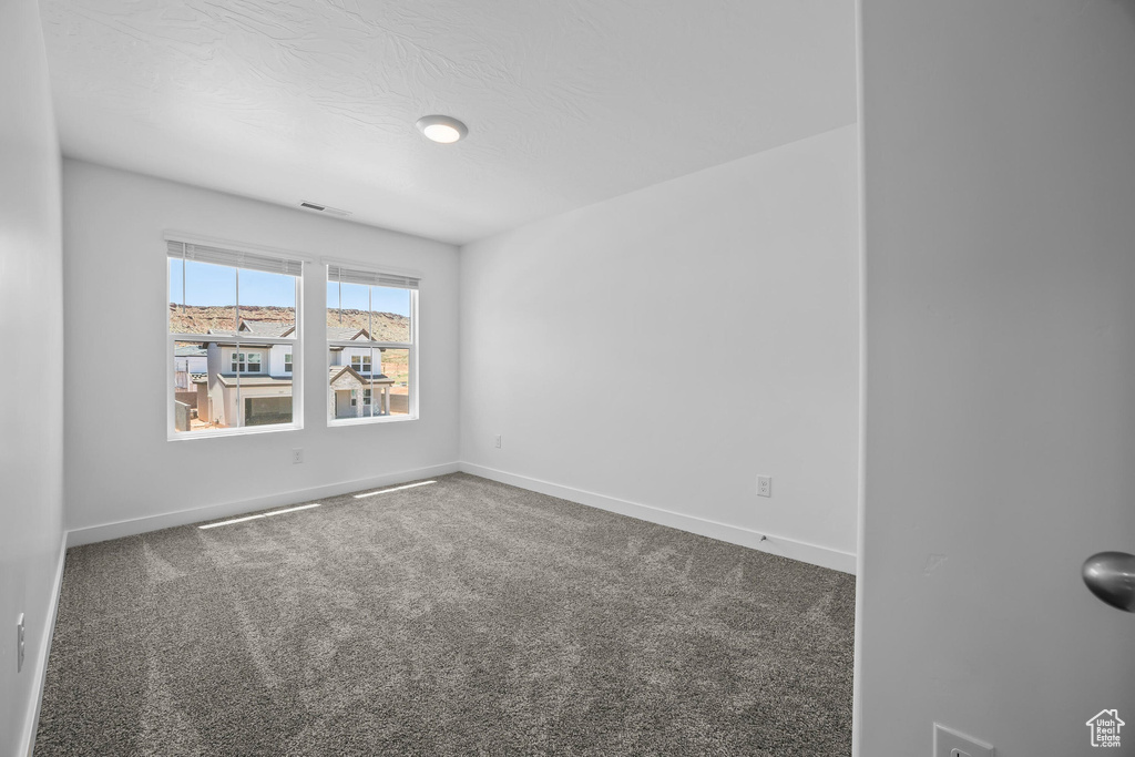 Carpeted spare room with baseboards