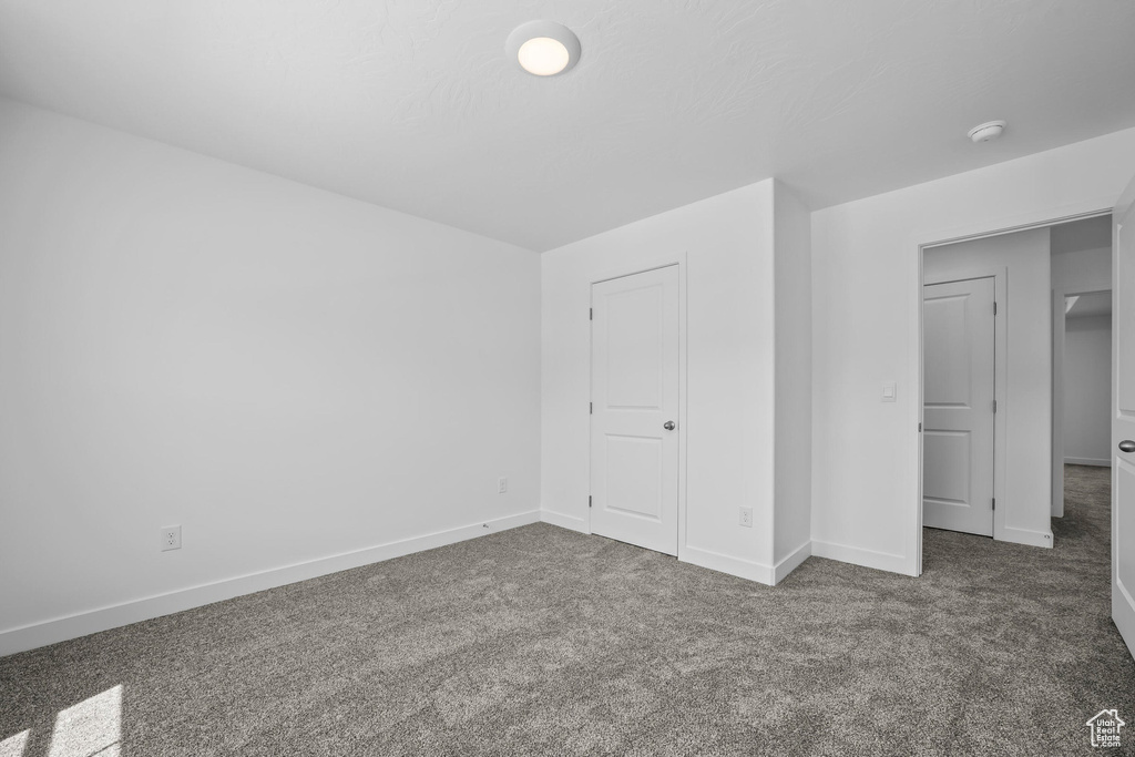Unfurnished bedroom featuring carpet flooring and baseboards