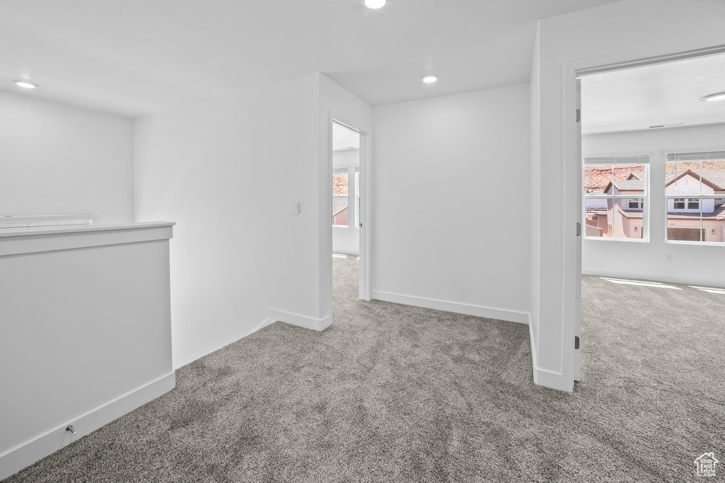 Carpeted spare room with baseboards and recessed lighting