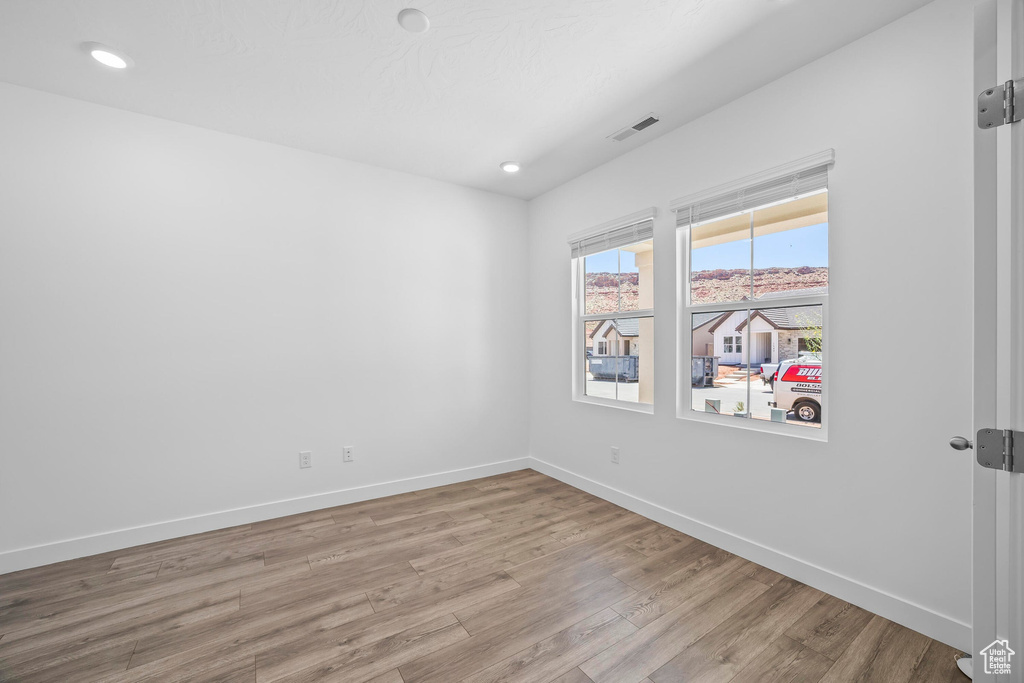 Unfurnished room featuring wood finished floors, baseboards, and recessed lighting