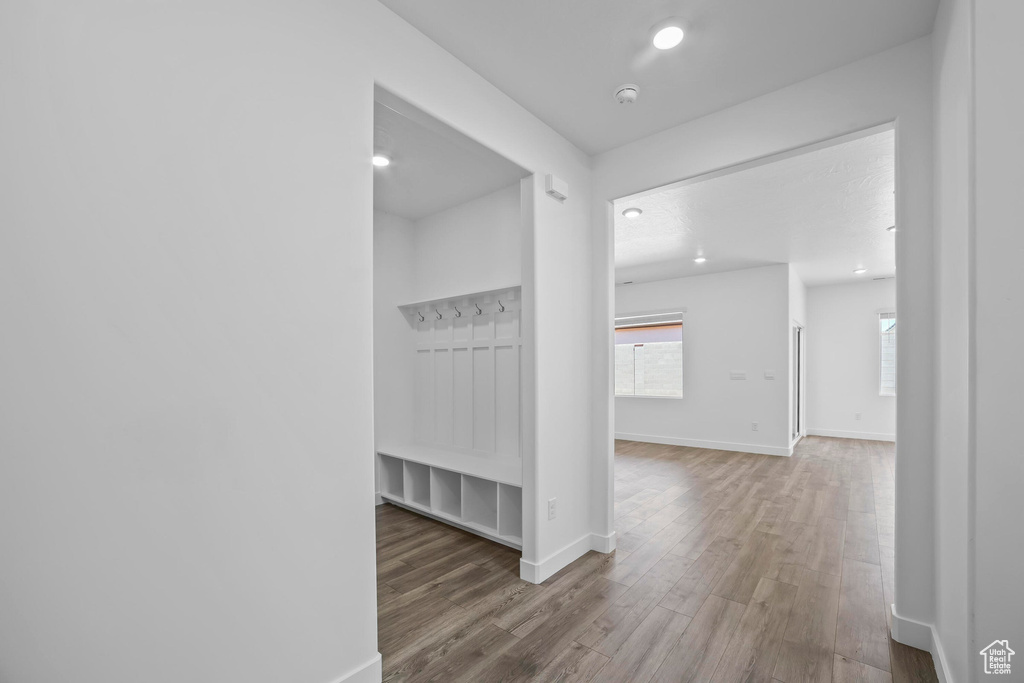 Hallway featuring wood finished floors, baseboards, and recessed lighting