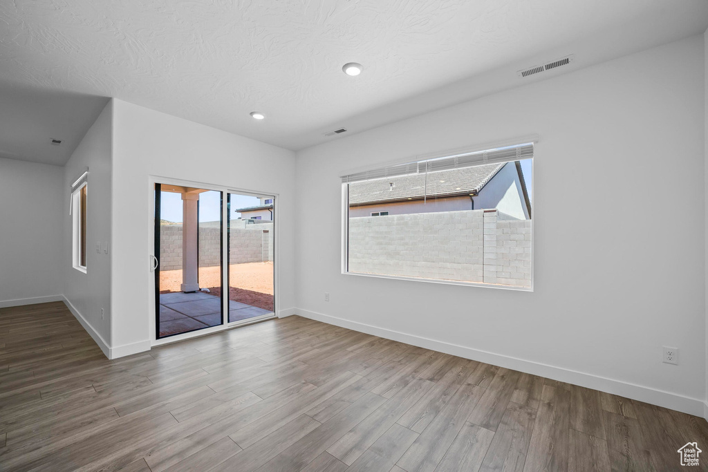 Spare room featuring baseboards, wood finished floors, and recessed lighting