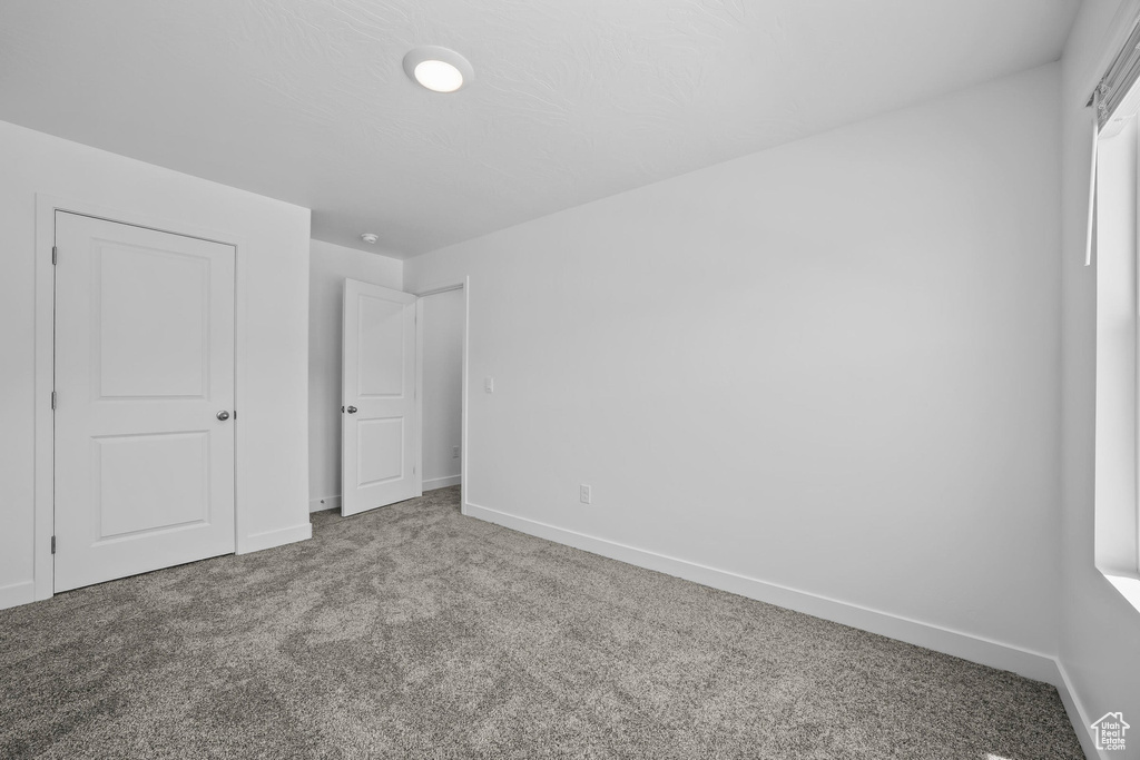 Unfurnished bedroom with carpet floors and baseboards