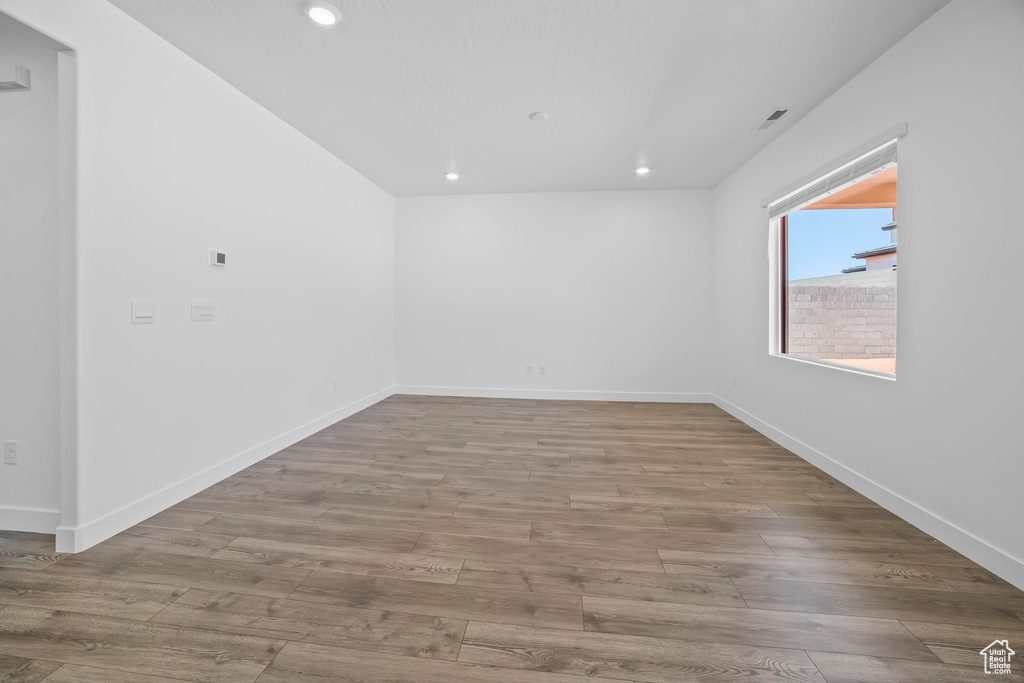 Spare room with recessed lighting, wood finished floors, and baseboards