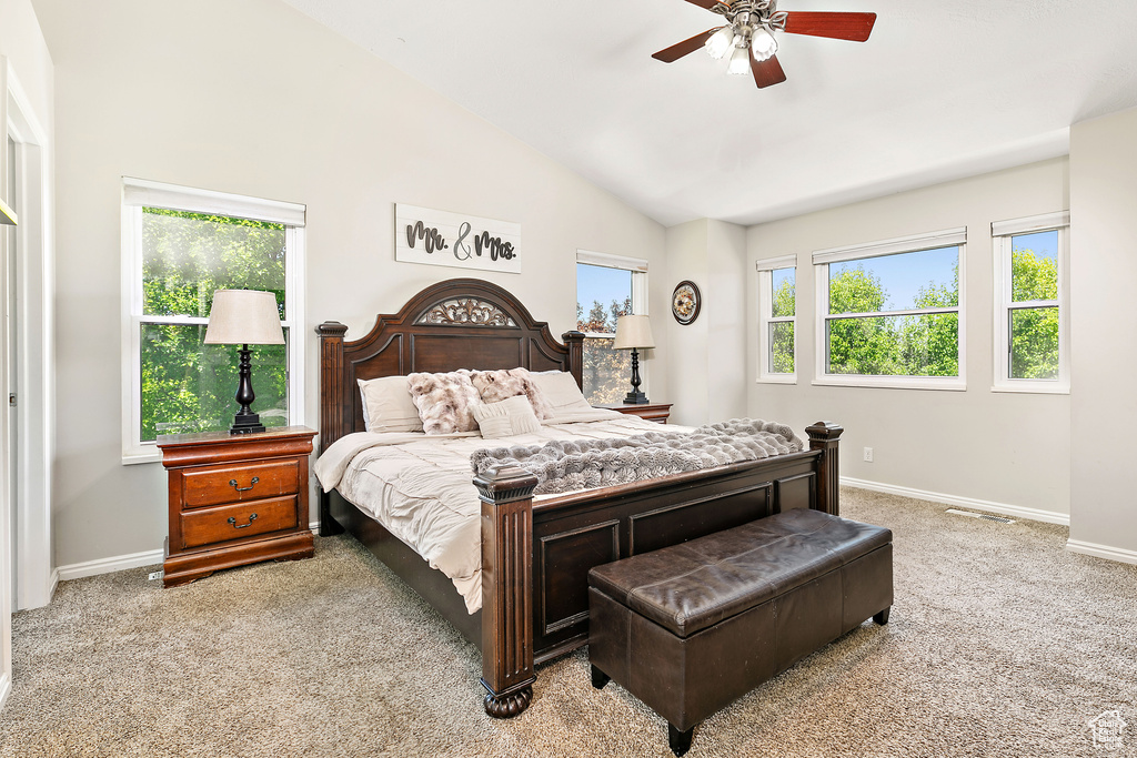 Bedroom featuring light carpet, baseboards, vaulted ceiling, and ceiling fan