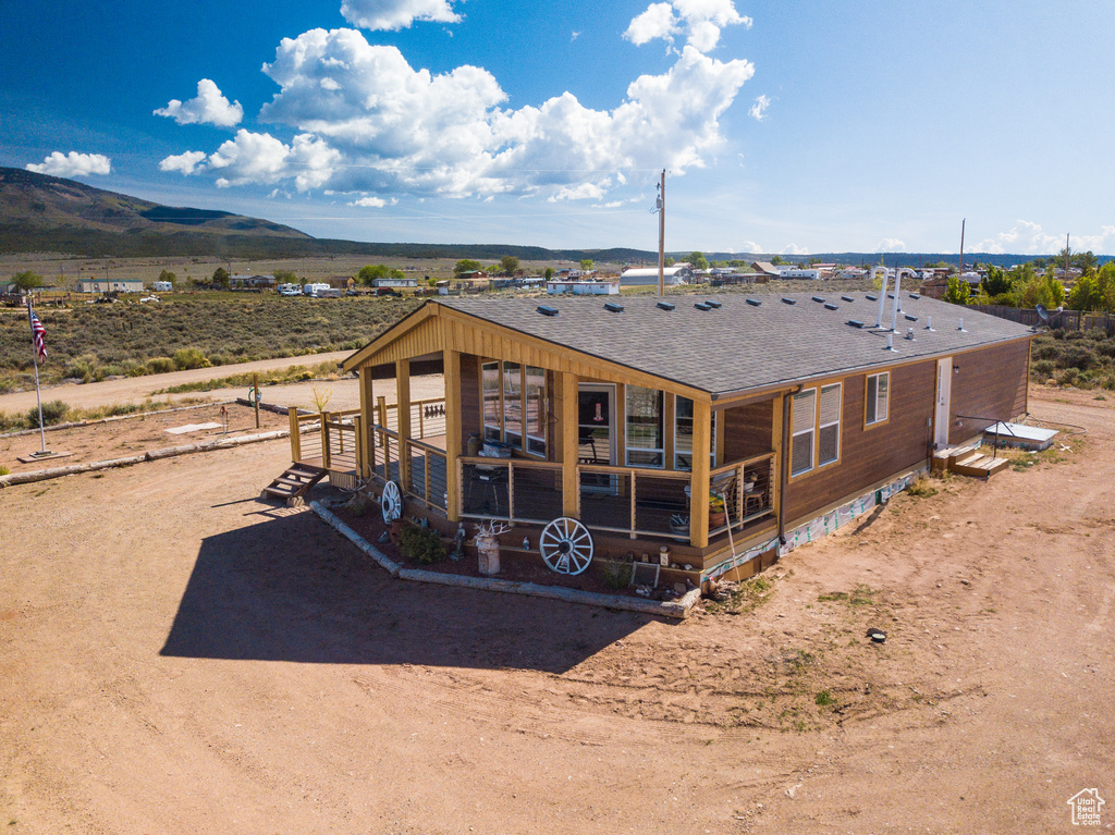 Back of house featuring a shingled roof and a mountain view