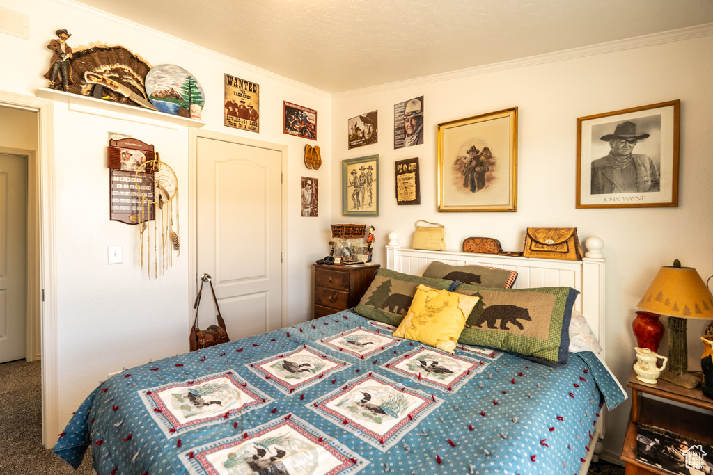 Bedroom with crown molding and carpet