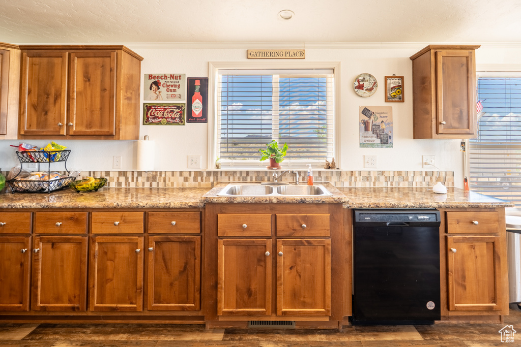 Kitchen with dishwasher, dark wood finished floors, brown cabinets, and ornamental molding