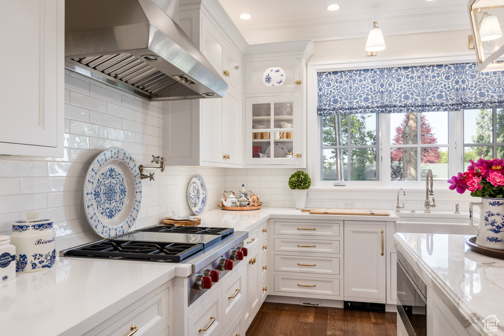 Kitchen featuring ventilation hood, appliances with stainless steel finishes, a sink, white cabinets, and recessed lighting