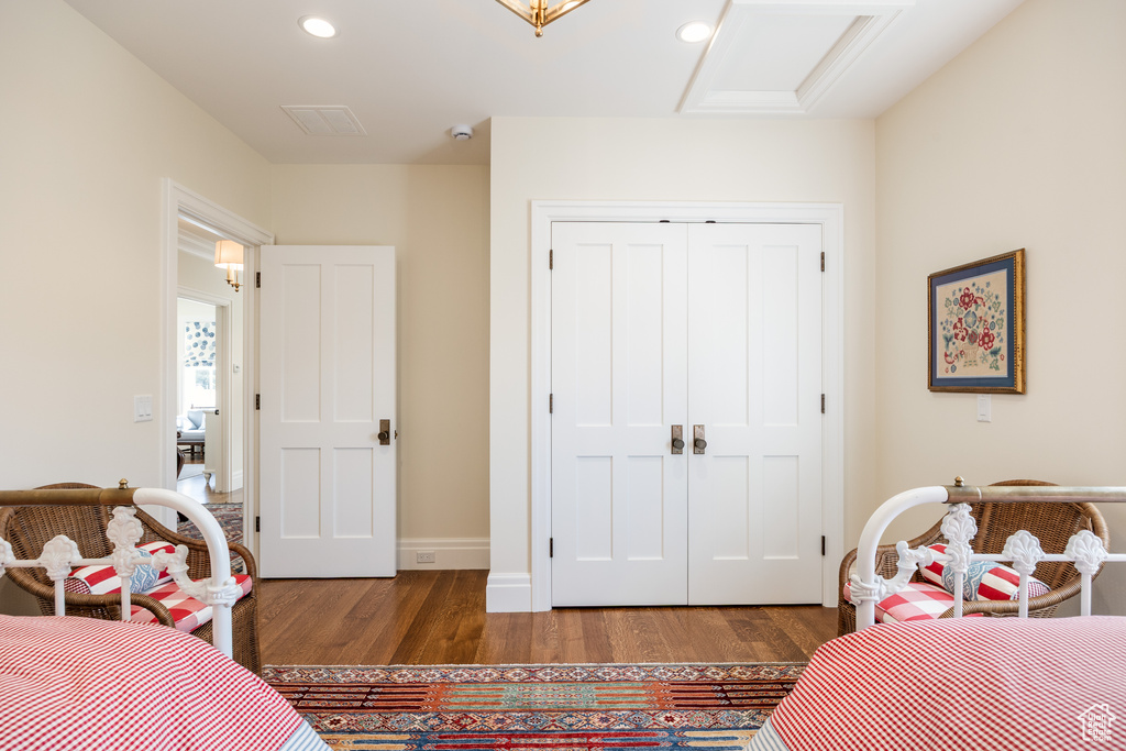 Bedroom featuring wood finished floors, a closet, recessed lighting, attic access, and baseboards