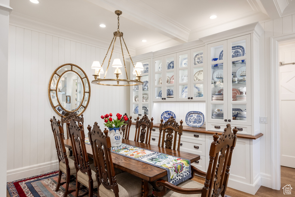 Dining space with crown molding, wood finished floors, a chandelier, baseboards, and recessed lighting