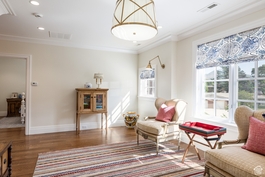 Living area featuring wood finished floors, ornamental molding, recessed lighting, and baseboards