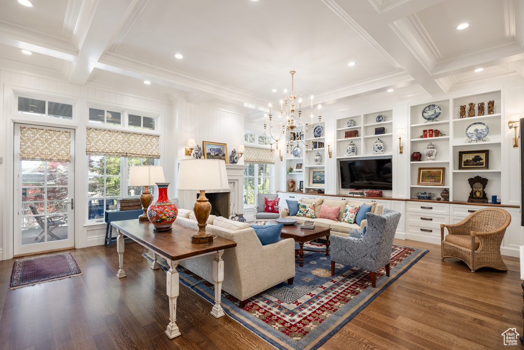 Living room with crown molding, healthy amount of natural light, wood finished floors, coffered ceiling, and beam ceiling