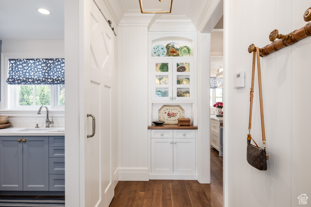 Corridor with a sink, dark wood-type flooring, recessed lighting, and crown molding