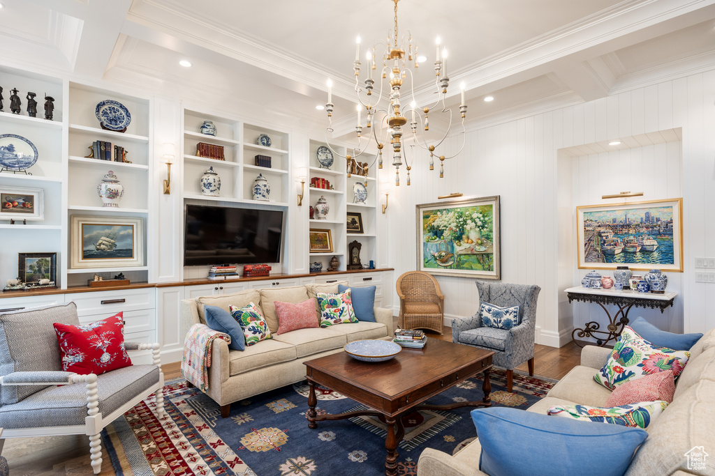 Living area featuring wood finished floors, crown molding, a chandelier, beam ceiling, and coffered ceiling