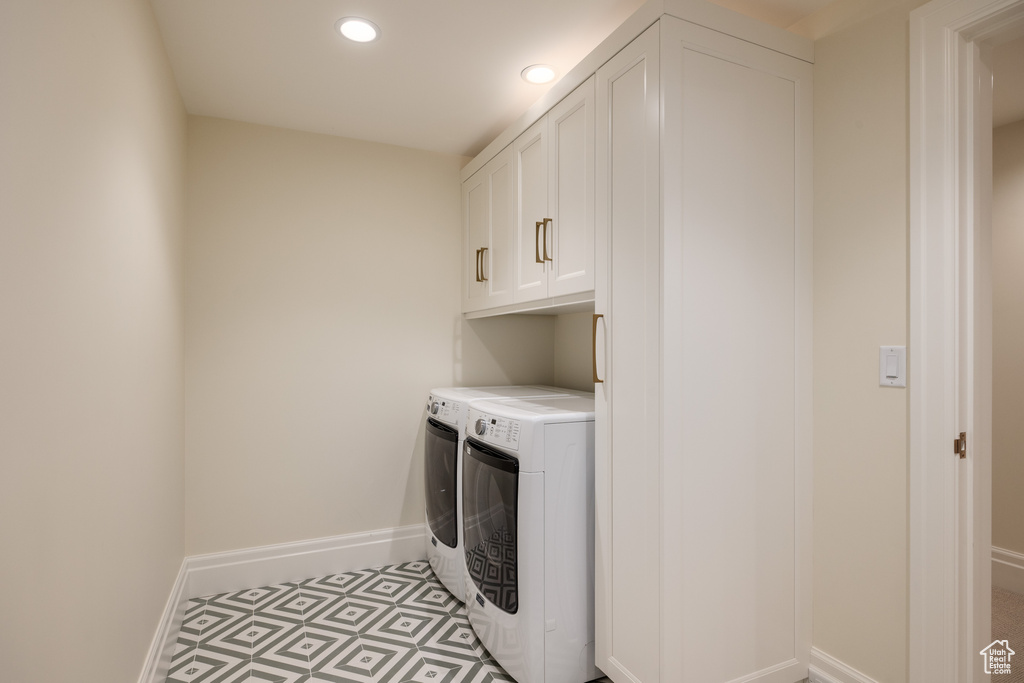 Washroom featuring separate washer and dryer, cabinet space, baseboards, and recessed lighting