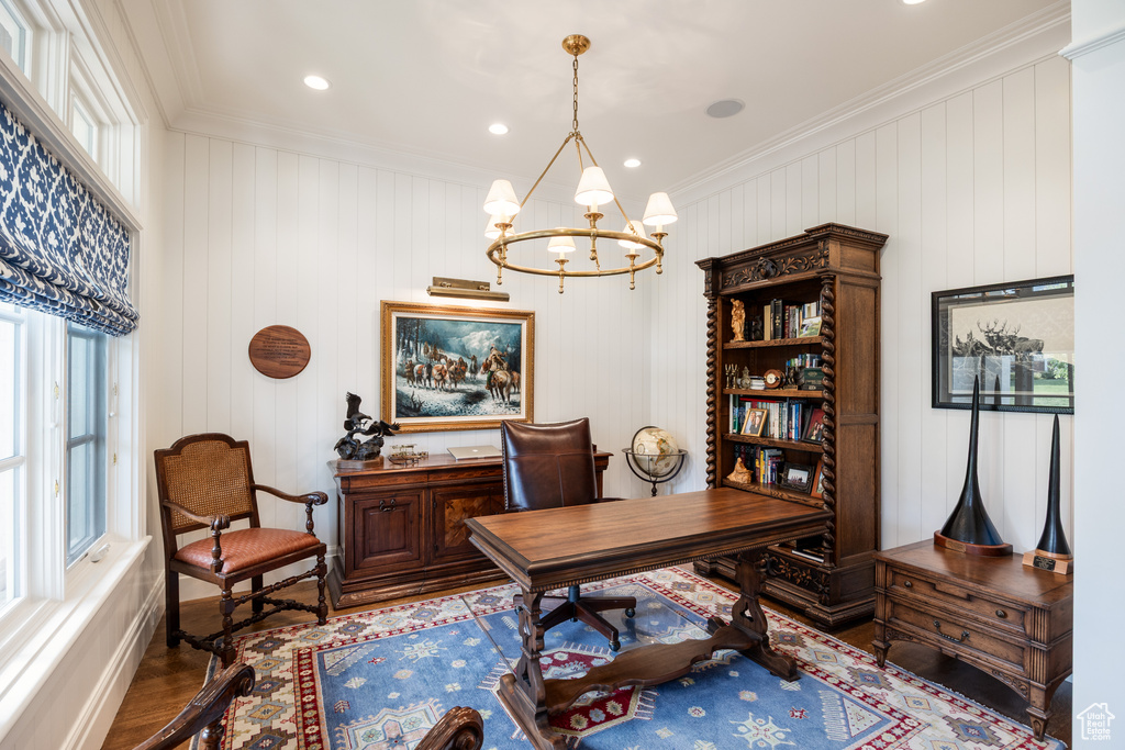 Home office featuring crown molding, healthy amount of natural light, wood finished floors, a chandelier, and baseboards