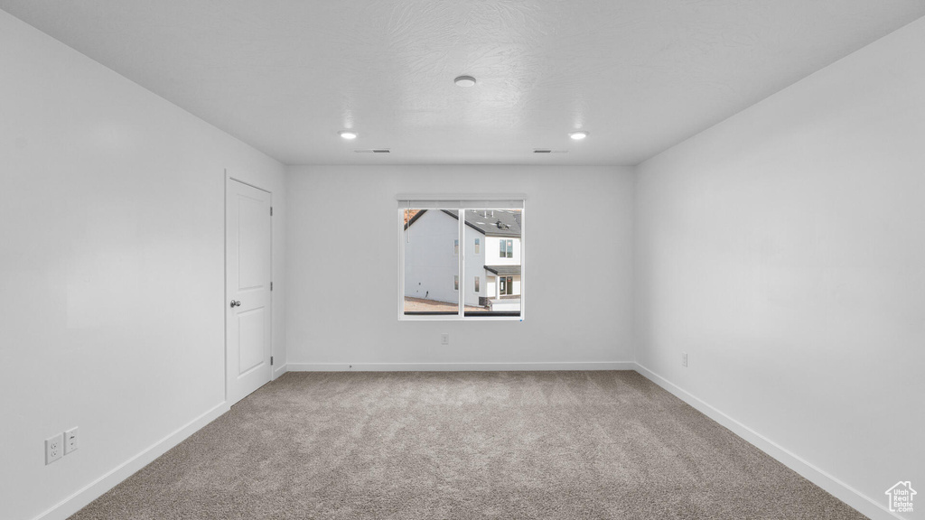 Empty room with carpet, recessed lighting, and baseboards