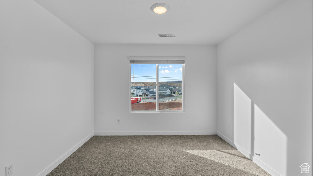 Carpeted empty room featuring baseboards