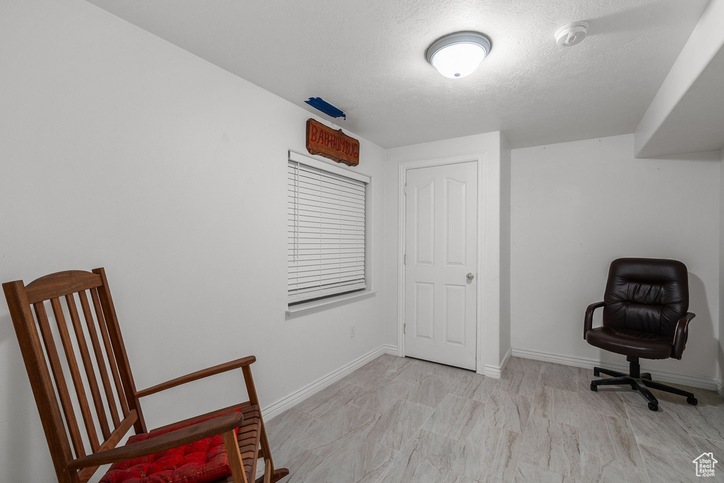 Sitting room with a textured ceiling and baseboards