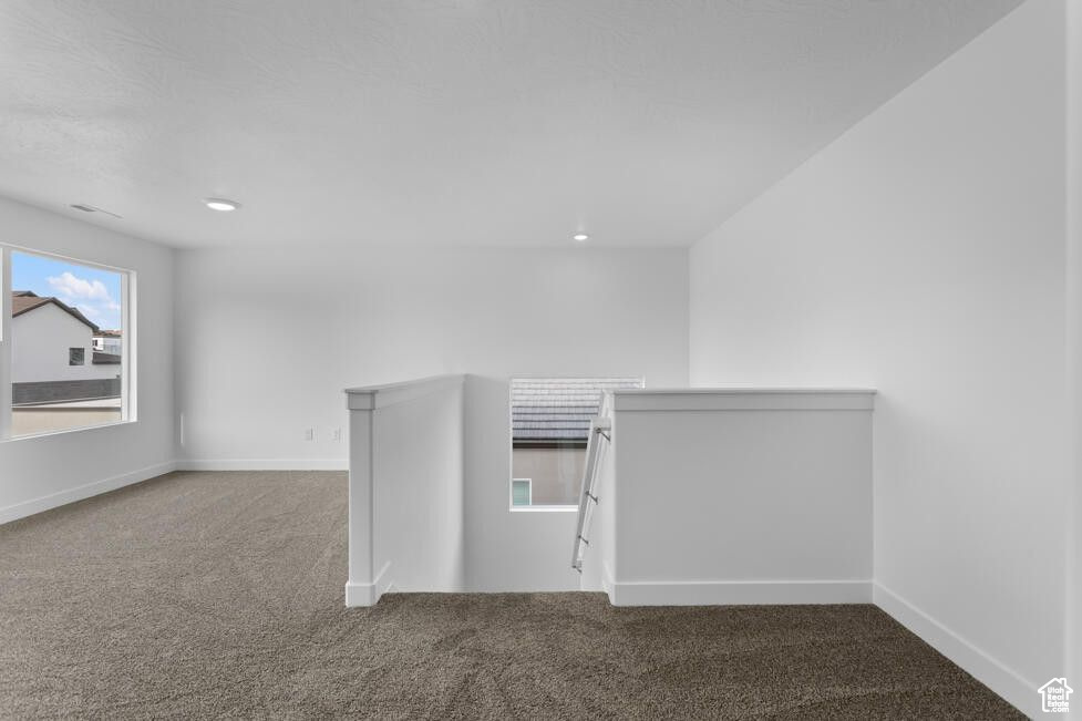 Additional living space featuring carpet floors and baseboards