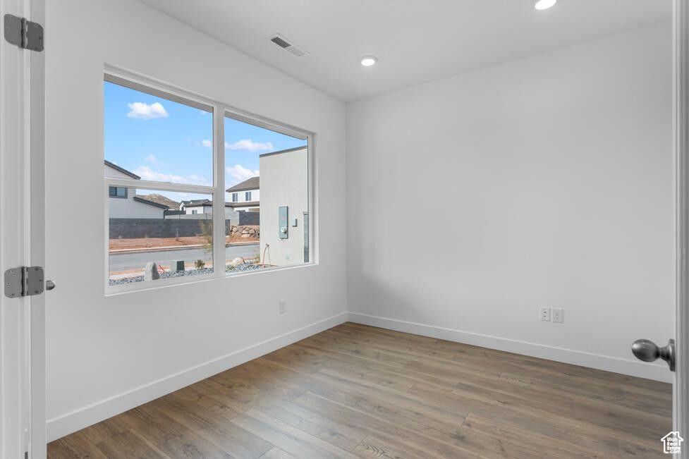 Spare room featuring baseboards, wood finished floors, and recessed lighting