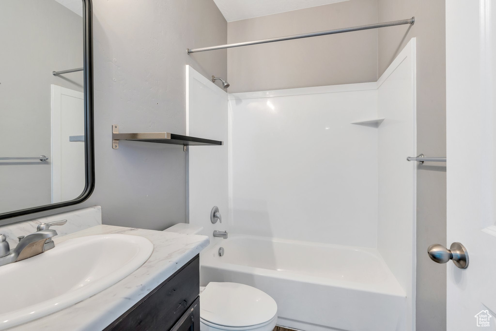 Bathroom featuring vanity, tub / shower combination, and toilet