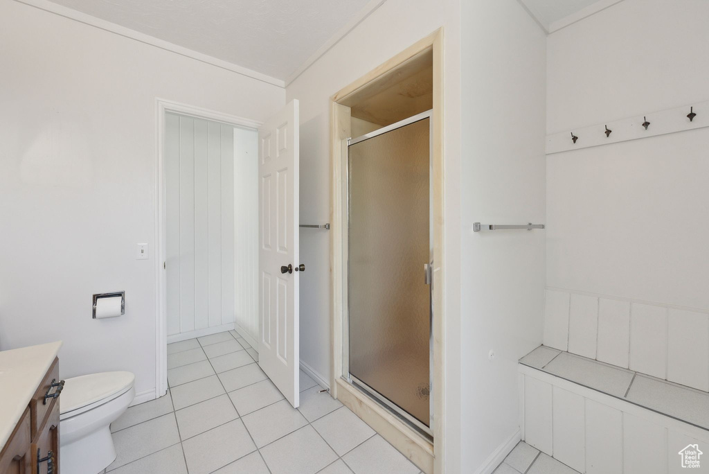 Bathroom with vanity, a shower stall, tile patterned flooring, and toilet