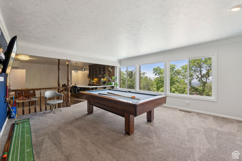 Rec room featuring pool table, carpet, ornamental molding, a textured ceiling, and baseboards