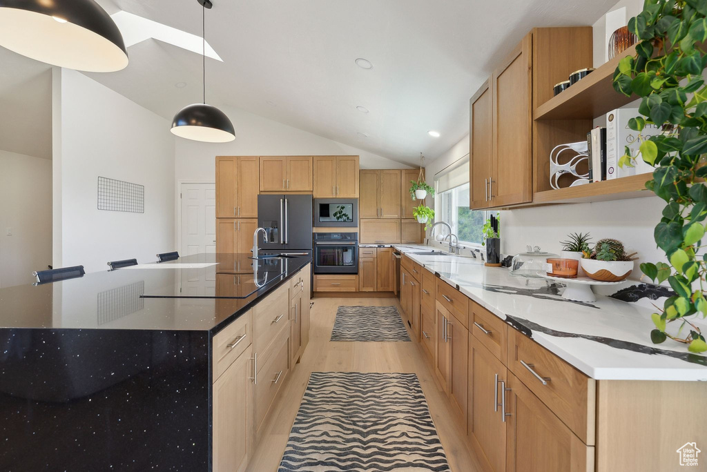 Kitchen with black appliances, open shelves, a sink, vaulted ceiling, and a spacious island