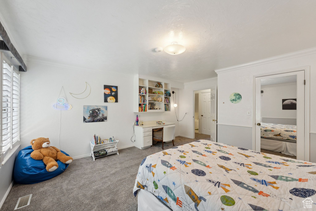 Carpeted bedroom featuring crown molding and baseboards