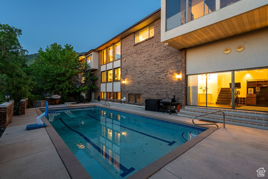 Outdoor pool featuring a patio area, entry steps, and grilling area