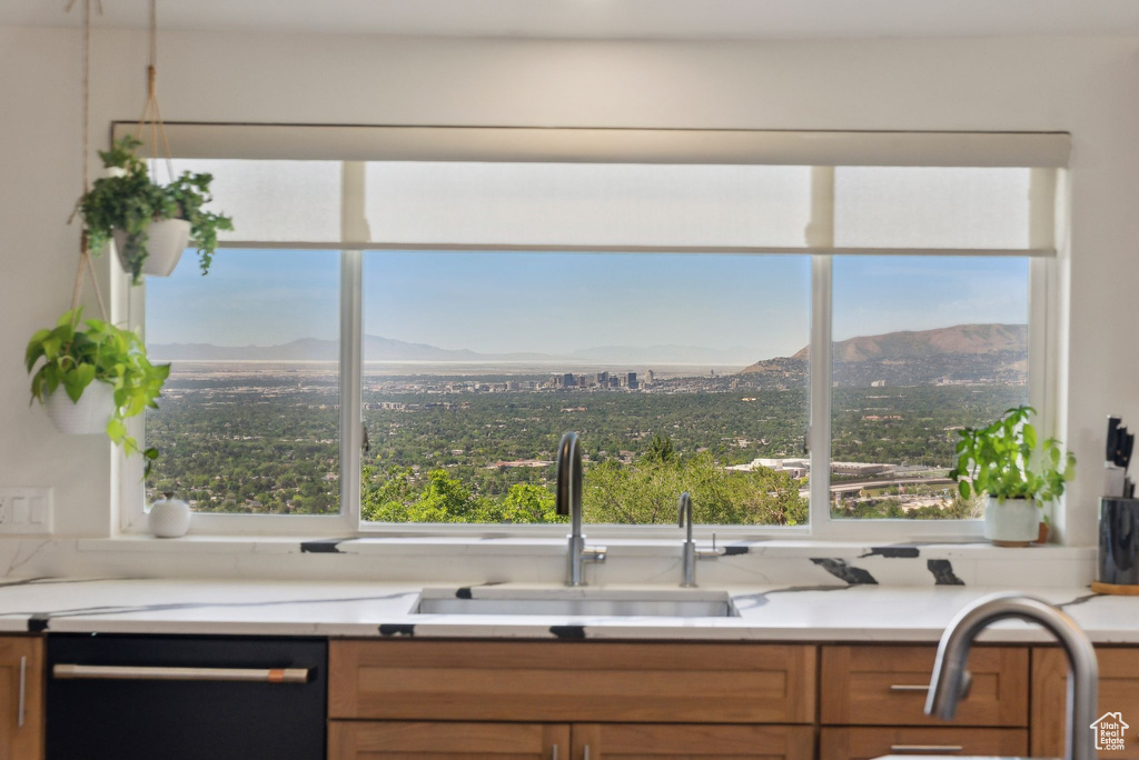 Kitchen with black dishwasher, a sink, a mountain view, and healthy amount of natural light