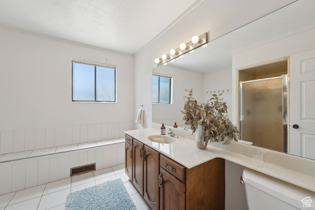 Full bathroom with toilet, vanity, a shower stall, and tile patterned flooring