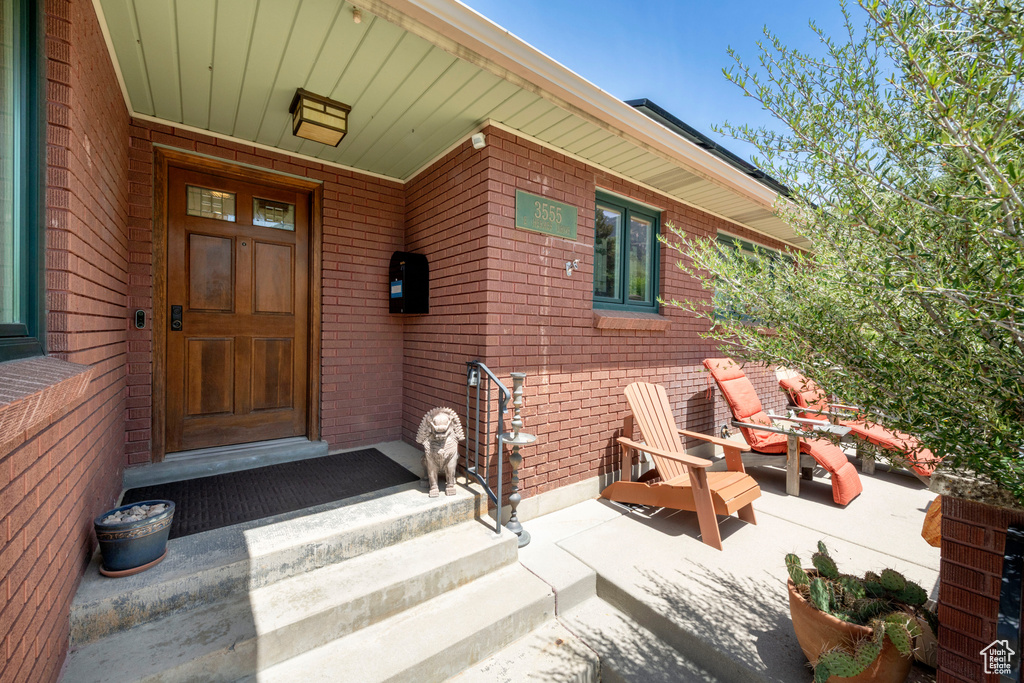 Doorway to property featuring brick siding