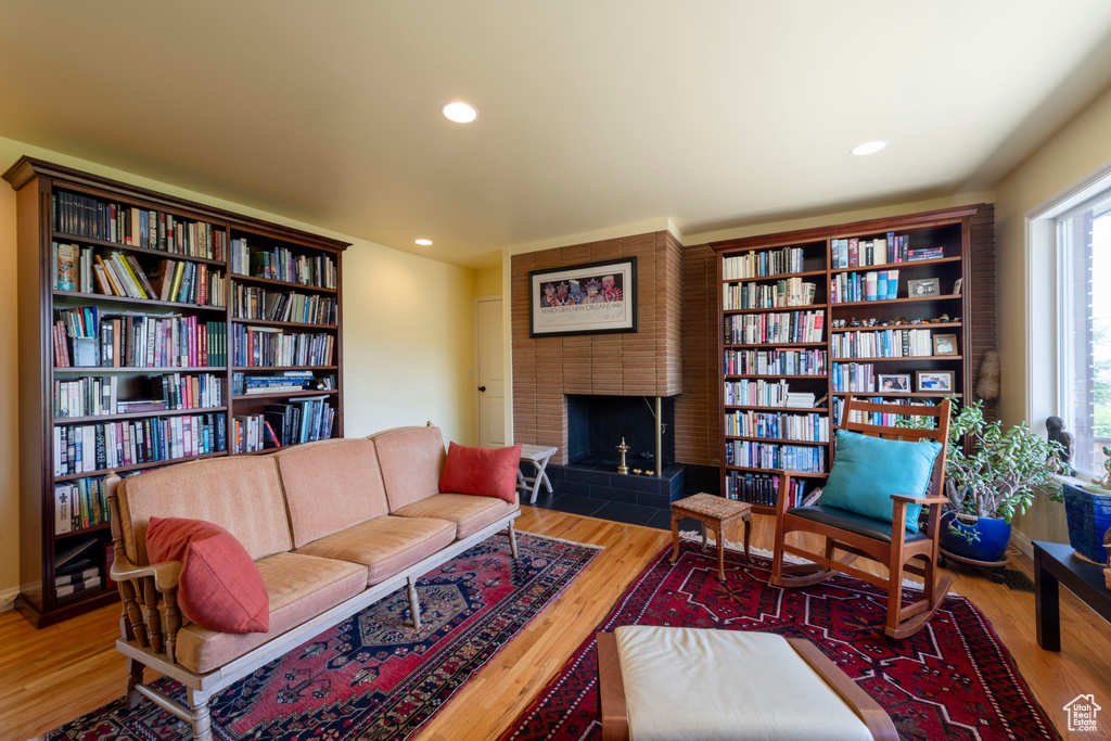 Living area featuring wood finished floors, a brick fireplace, and recessed lighting