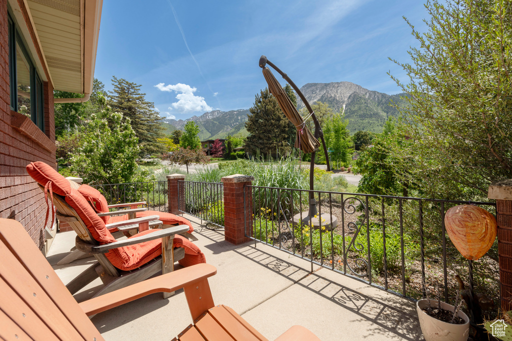 View of patio with a mountain view and a balcony