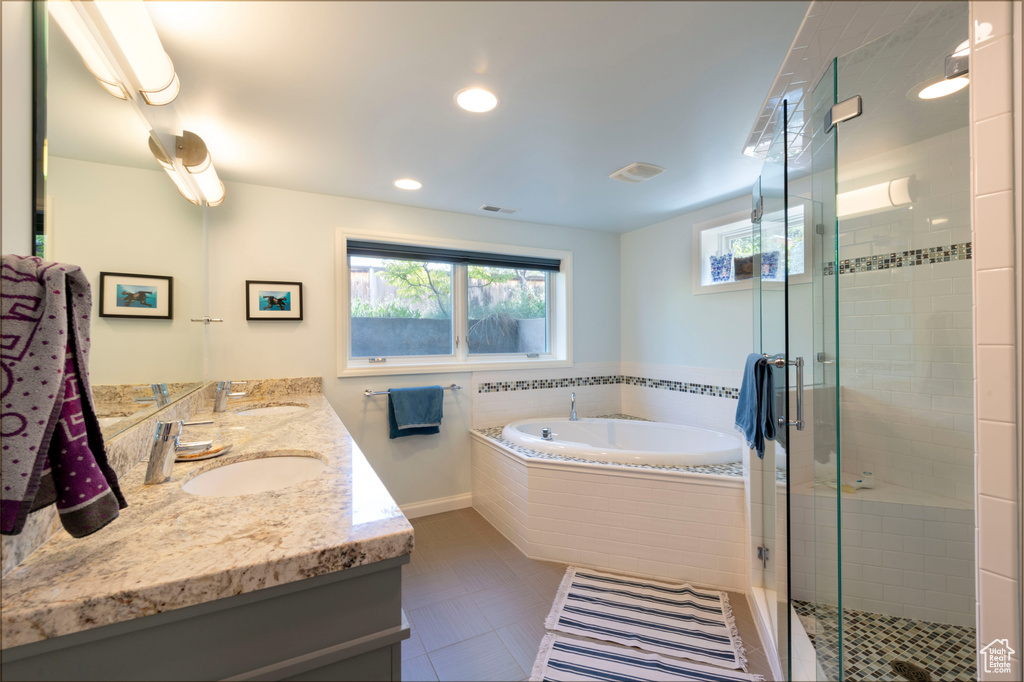 Full bath featuring double vanity, a bath, a stall shower, and recessed lighting