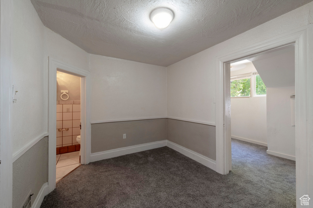 Carpeted empty room featuring a textured ceiling