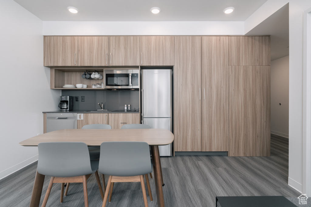Dining space featuring dark wood-style flooring, baseboards, and recessed lighting