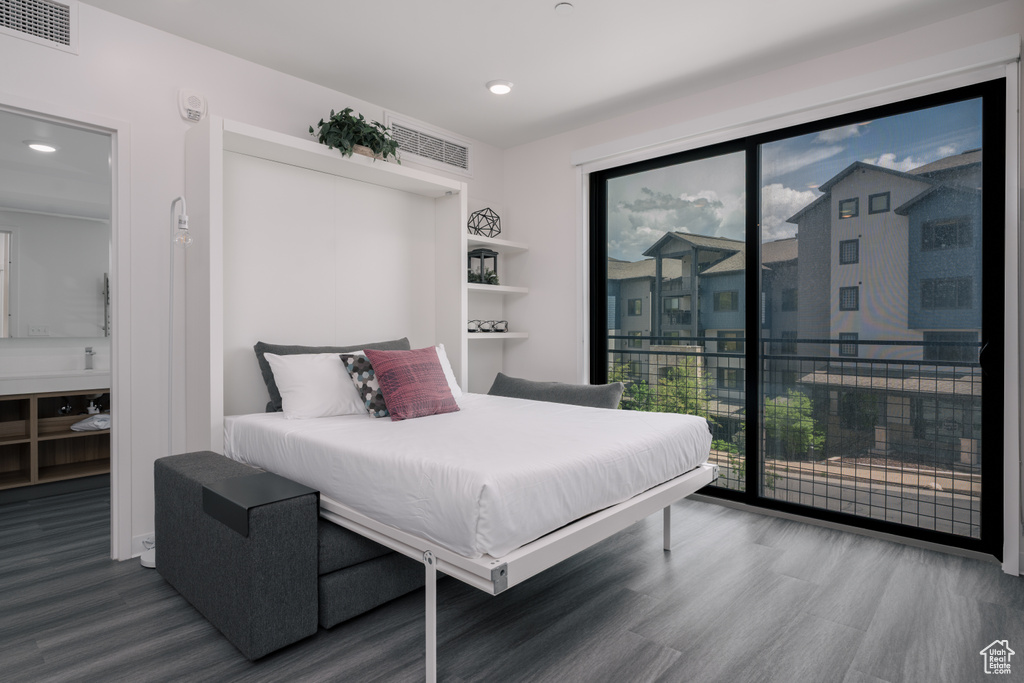Bedroom featuring wood finished floors, access to exterior, multiple windows, and recessed lighting