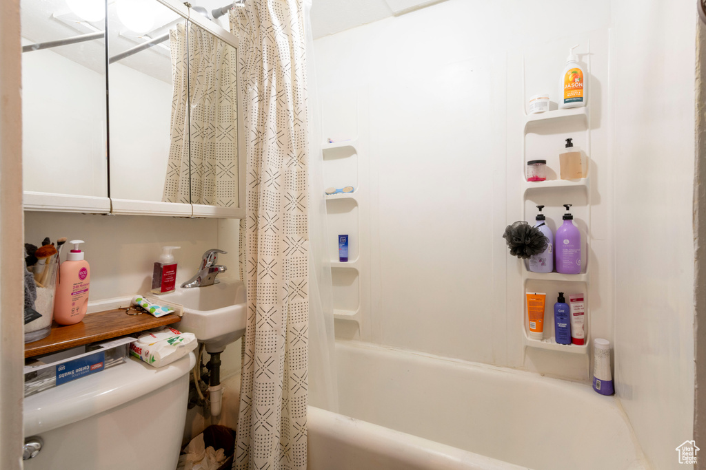 Full bathroom with shower / bathtub combination with curtain and toilet