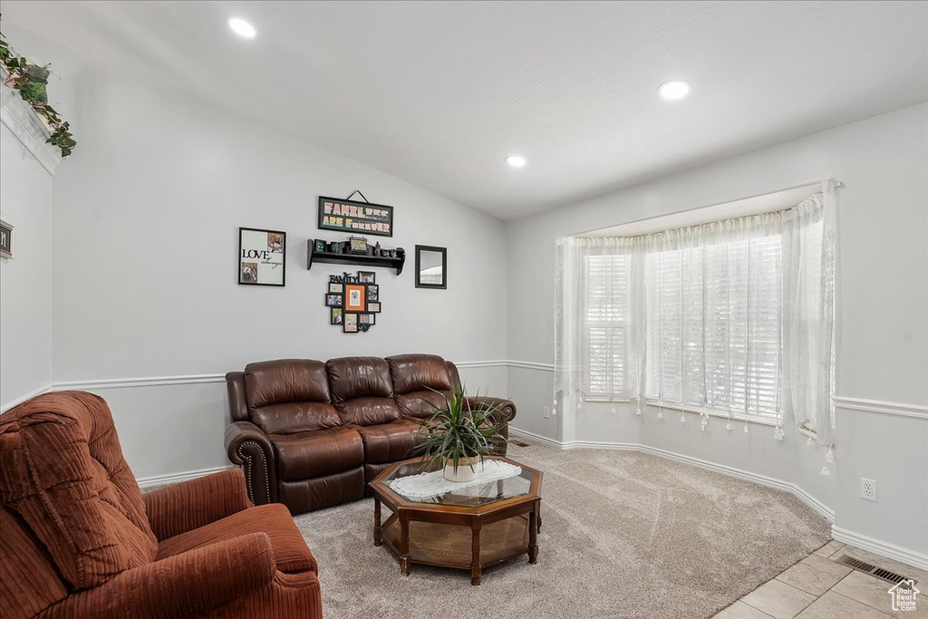Living area with recessed lighting, vaulted ceiling, baseboards, and tile patterned flooring
