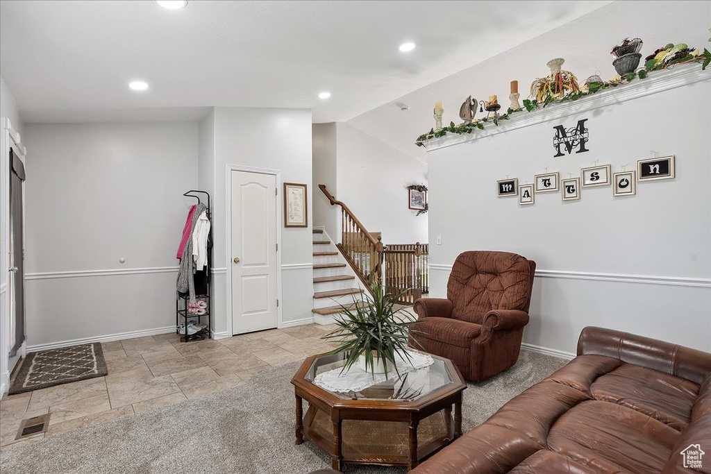 Living room with stairway, vaulted ceiling, baseboards, recessed lighting, and light stone finish flooring