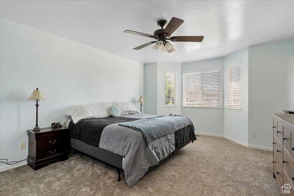Carpeted bedroom with baseboards and ceiling fan